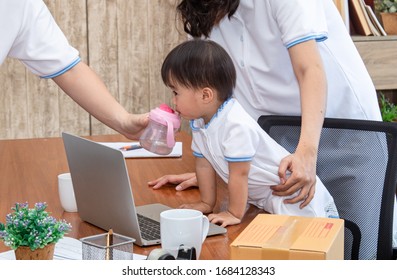 Asian Young Family Help Together Feeding Adorable Cute Girl At Home, Father Making Small Business Marketing Online Logistic Home Office, Mother Playing With Child, Parenthood Duty Multi Task Concept