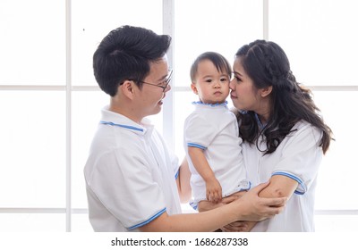 Asian Young Family Help Together Feeding Adorable Cute Girl At Home, Father Making Small Business Marketing Online Logistic Home Office, Mother Playing With Child, Parenthood Duty Multi Task Concept