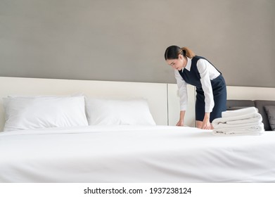 Asian Young Female Hotel Maid In Uniform Making Bedroom In Hotel Room