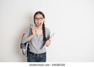 Asian Young Female Student In Suprise Look With Plain Background 