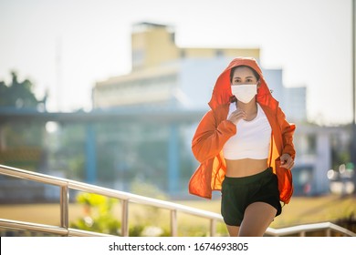 Asian Young Fitness Sport Woman Running  And She Wears A Mask For Protective Dust And Pollution And Protection Flu Virus, Influenza, Coronavirus On City 