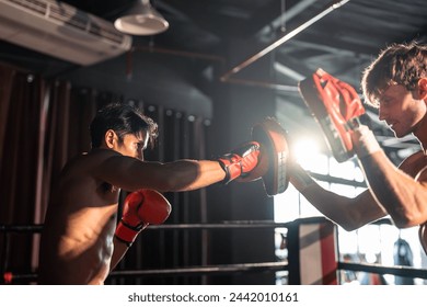 Asian young fitness trainer support Caucasian sportsman doing boxing. Attractive athlete boxer people workout and exercise by practice punching with coach for health care at gym stadium club.
 - Powered by Shutterstock