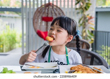 Asian Young Girl Eating Chicken Nuggets Fast Food On Table.