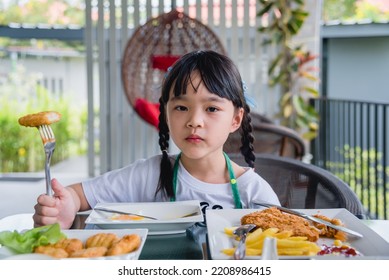 Asian Young Girl Eating Chicken Nuggets Fast Food On Table.