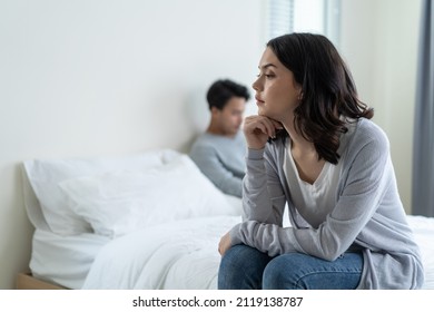Asian young girl feel angry boyfriend having conflict domestic problem. New marriage man and woman feel heartbroken for quarrel conflict while sit on bed in bedroom. Family problem-separation concept. - Shutterstock ID 2119138787
