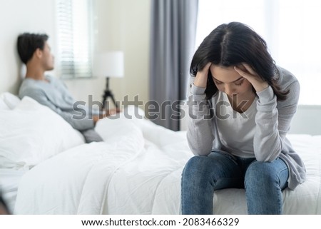 Asian young girl feel angry boyfriend having conflict domestic problem. New marriage man and woman feel heartbroken for quarrel conflict while sit on bed in bedroom. Family problem-separation concept.