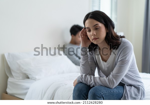 Asian young girl feel angry boyfriend having\
conflict domestic problem. New marriage man and woman feel\
heartbroken for quarrel conflict while sit on bed in bedroom.\
Family problem-separation\
concept.