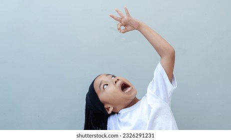 asian young girl pretending put in something to the mouth - Powered by Shutterstock