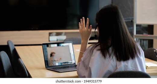 Asian Young Girl Student Learning Virtual Internet Online Class From School Teacher By Remote Meeting Due To Covid Pandemic. Female Teaching By Using Headphone And Whiteboard