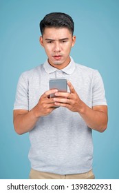 Asian Young Handsome Attractive Man With Smart Phone On Blue Background