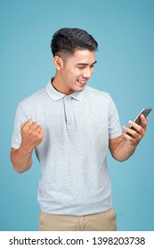 Asian Young Handsome Attractive Man With Smart Phone On Blue Background