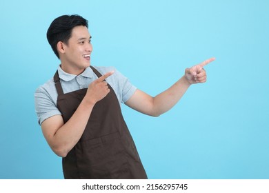 Asian young handsome man in waiter uniform, welcome guest and take order, isolated on blue background - Shutterstock ID 2156295745