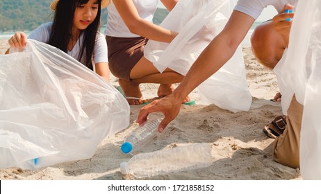 Asian young happy family activists collecting plastic waste on beach. Asia volunteers help to keep nature clean up and pick up garbage. Concept about environmental conservation pollution problems. - Powered by Shutterstock