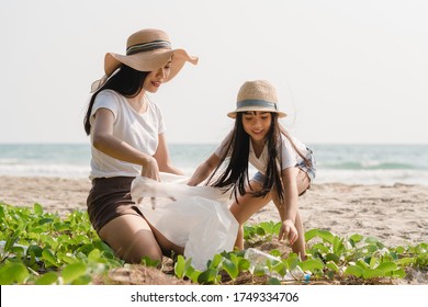 Asian young happy family activists collecting plastic waste on beach. Asia volunteers help to keep nature clean up and pick up garbage. Concept about environmental conservation pollution problems. - Powered by Shutterstock