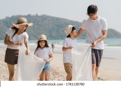 Asian Young Happy Family Activists Collecting Plastic Waste And Walking On Beach. Asia Volunteers Help To Keep Nature Clean Up Garbage. Concept About Environmental Conservation Pollution Problems.