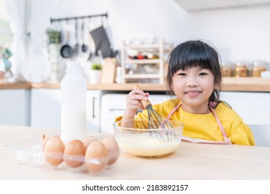 Asian Young Kid Girl Doing Pancake Homemade Bakery Alone In Kitchen. Little Cute Child Sitting On Table With Smile Feel Happy And Enjoy Learning To Cooking Foods Or Baking Kneads Yeast Dough At Home. 