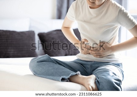 Asian young lady girl holding abdomen,acute abdominal pain with appendicitis,painful and inflammation of appendix,sick female patient with Stomachache,Ruptured Appendicitis,health care,medical concept