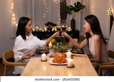 Asian Young Lesbian Couple Have A Romantic, Candlelit Dinner In Her Home.