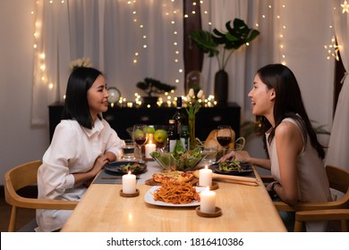 Asian Young Lesbian Couple Have A Romantic, Candlelit Dinner In Her Home.