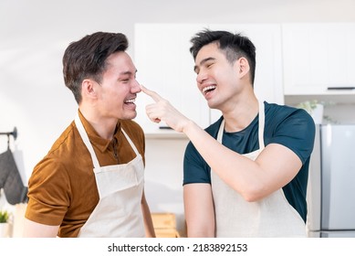 Asian Young LGBTQ Male Gay Couple Enjoy Bake Bakery In Kitchen At Home. Attractive Handsome Romantic Man Couple Wear Apron Cooking Food Feeling Happiness And Cheerful To Spend Time Together In House.