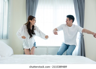 Asian Young Loving Couple Dance With Music Together In Bedroom At Home. Attractive Romantic New Marriage Man And Woman Enjoy Spend Time Listen And Sing Song After Wake Up In The Early Morning In House