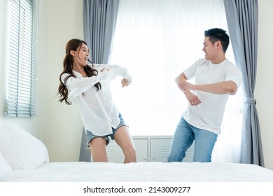 Asian Young Loving Couple Dance With Music Together In Bedroom At Home. Attractive Romantic New Marriage Man And Woman Enjoy Spend Time Listen And Sing Song After Wake Up In The Early Morning In House