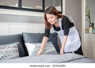 Asian Young Maid Tidying Up Bed In Hotel Room, Cleaning Service Concept