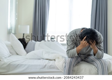 Asian young male feel angry boyfriend having conflict domestic problem. New marriage man and woman feel heartbroken for quarrel conflict while sit on bed in bedroom. Family problem-separation concept.