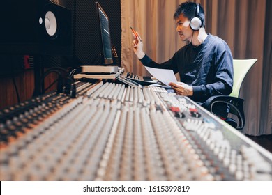 asian young male professional music producer, sound engineer, composer, arranger working in home recording studio. post production and broadcasting concept - Powered by Shutterstock