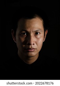 Asian Young Man Closes Up Portrait, On Black Background Low Key.