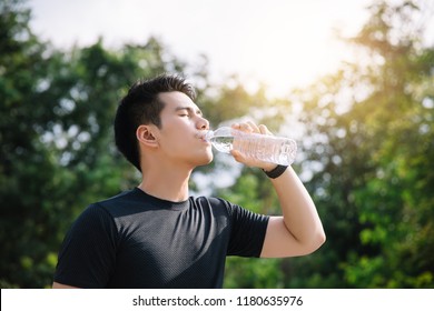 Asian young Man drinking water after jogging