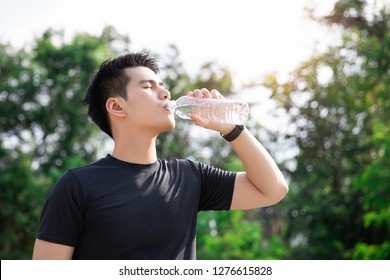 Asian Young Man Drinking Water After Jogging