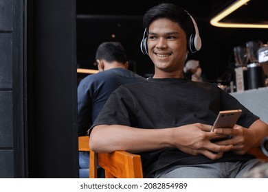 Asian Young Man Enjoying Time At Coffee Shop