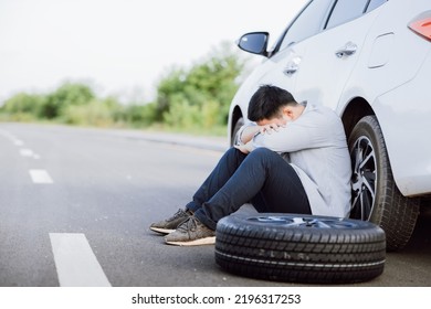 Asian Young Man Failed To Fix A Problem On The Road, Car Broke Down Or Changing Flat Tire On The Road Concept.