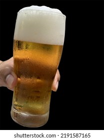 Asian Young Man Hand Holding A Glass Of Beer With Light White Foam, Isolated On A Black Background.no Focus