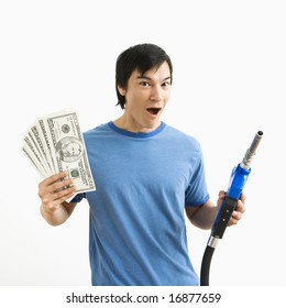 Asian Young Man With Happy Expression Holding Money And Gas Pump Nozzle.