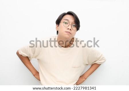 asian young man having doubt with unsure expression. man raising eye brow to intimidate.