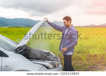 Asian young man having trouble car engine overheating and have smoke. Automotive motor problem concept.