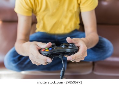 An Asian Young Man Holding Game Controller Playing Video Games