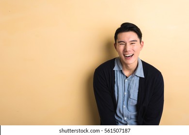 Asian Young Man Laughing In The Studio Yellow Background