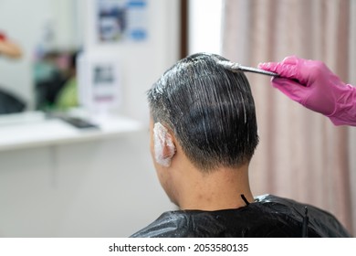 Asian Young Man Making A Hair Dye At Hair Salon And Spa. Professional Hair Stylist Coloring - Dying Hair In Male Salon.