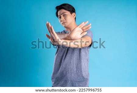 Asian young man posing on blue background
