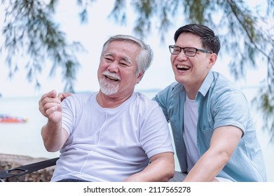 Asian young man take care and warn hug father, he is very happy and smile in outdoor  background.