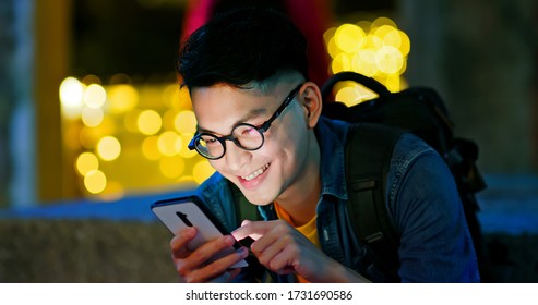 Asian Young Man Use Smart Phone Outdoor In The City At Night