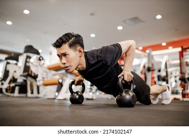 Asian Young Man Using Dumbbell Pushing Up Exercise At Gym For Good Healthy In Fitness, Lifestyle And Sport Exercise Concept. 