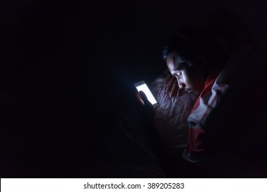 Asian Young Man Using His Mobile Phone On The Bed In Dark Room.
Asian Young Man Sleeping In Bed And Holding A Mobile Phone. Concept Photo Of Smart Phone Addiction