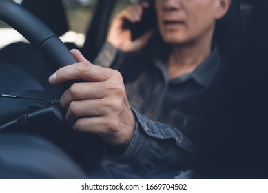 Asian young man using mobile smart phone calling while driving a car, Driver talking via smartphone inside a car, close up. Transportation, people lifestyle concept - Shutterstock ID 1669704502