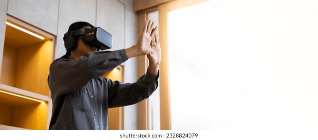 Asian young man using virtual reality headset. VR Glasses gadgets new technology for lifestyle