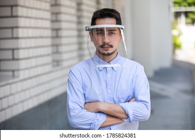 Asian Young Man Wearing Face Shield For Healthcare Which Is Required For Doctor And General Public To Prevent COVID-19.