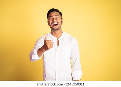 Asian Young Man Wearing White Shirt Laughing With Thumbs Up